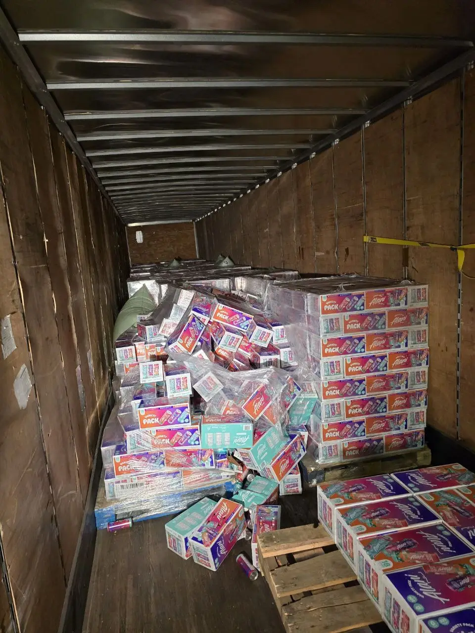 Warehouse workers restacking and reworking freight on pallets to prepare for re-delivery after load rejection.