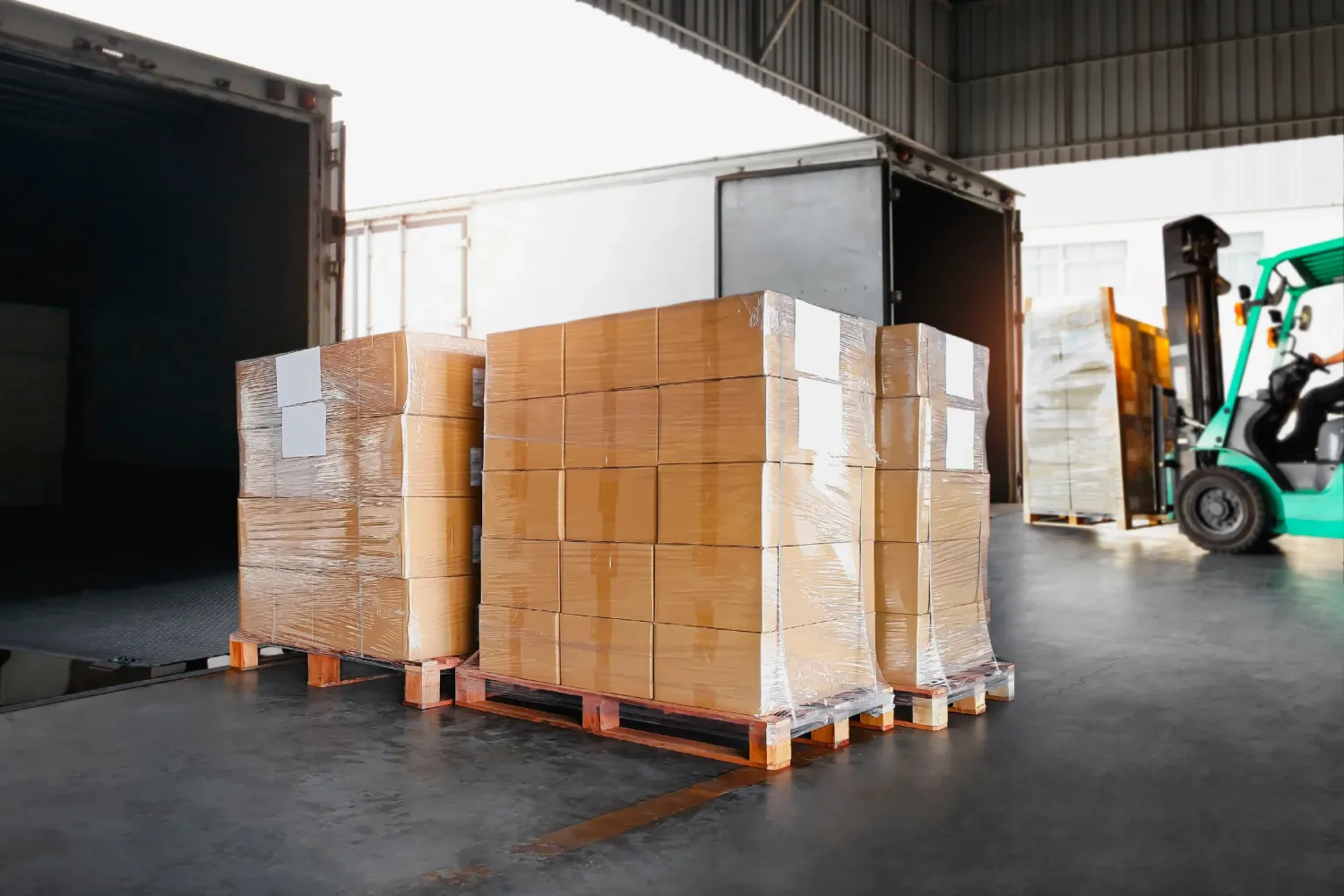 Forklift moving pallets in a warehouse as part of a consolidated freight shipment for efficient transport.
