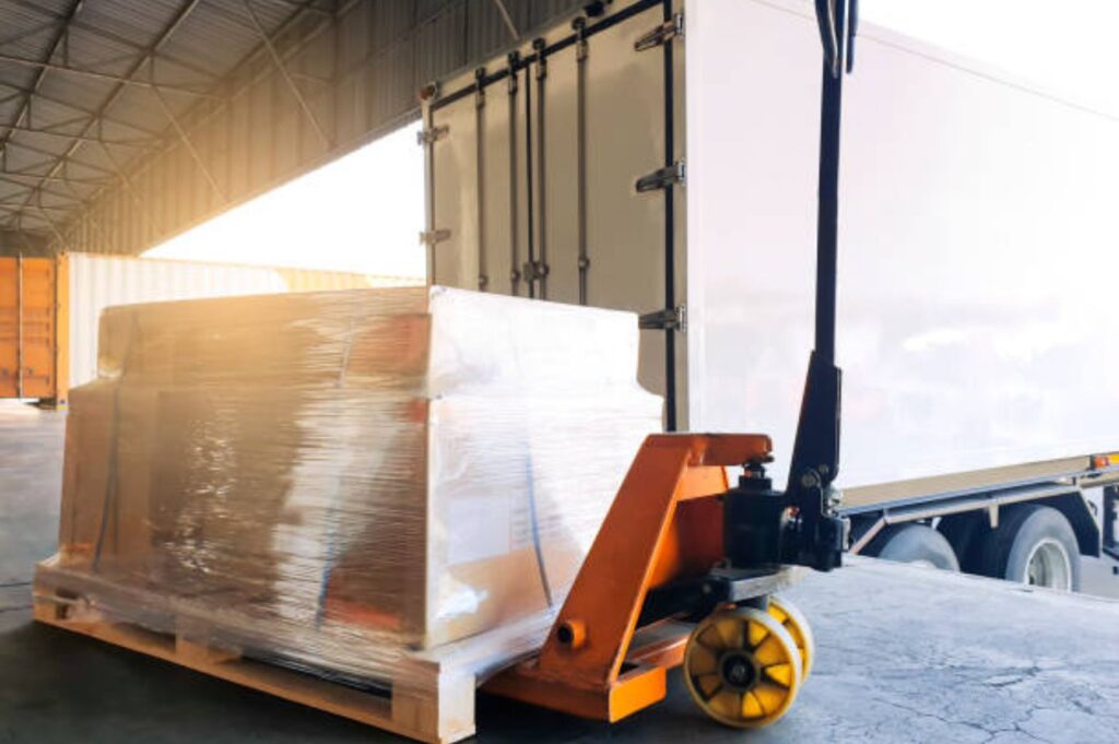 Warehouse interior with forklift and pallets, showing on-site pallet restacking and loading operations.