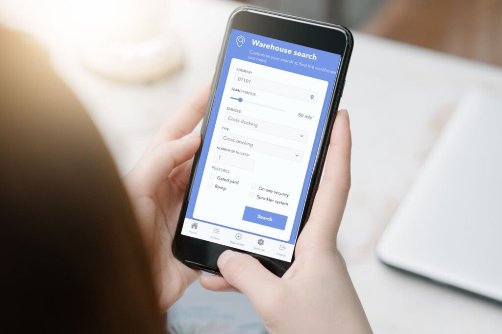 Phone with our app, where our can search for a warehouse by distance, pricing and reviews.