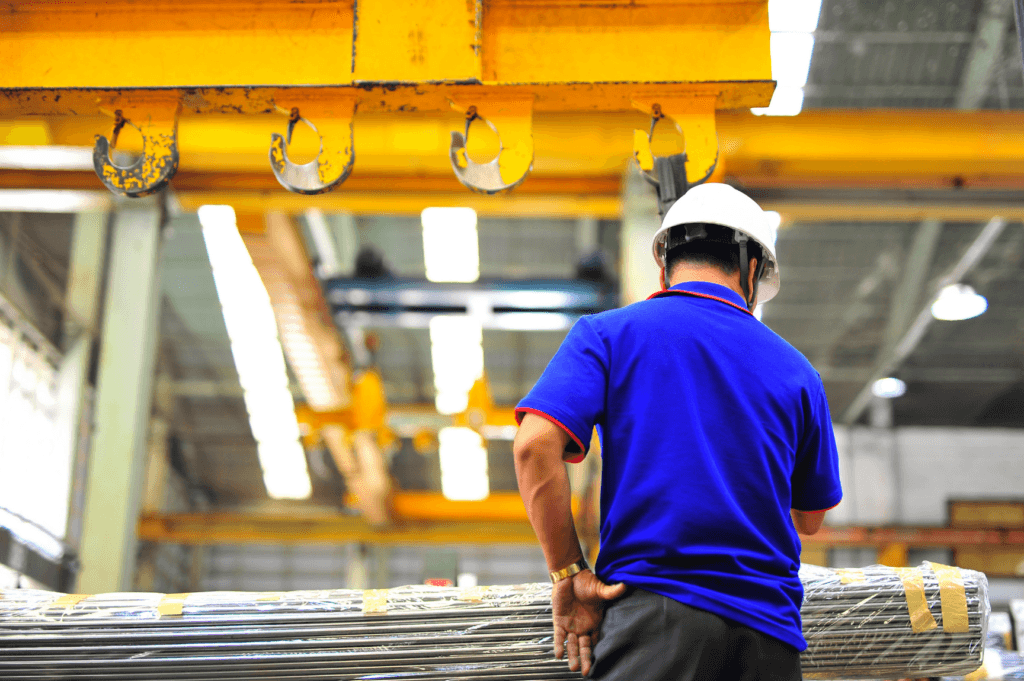 Warehouse overhead crane system storing pallets in narrow-aisle racking, doubling storage capacity