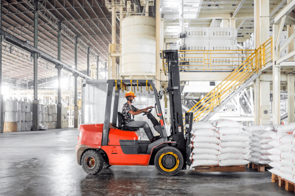 Interior of an OLIMP warehouse with a high-capacity heavy-duty forklift moving oversized freight.