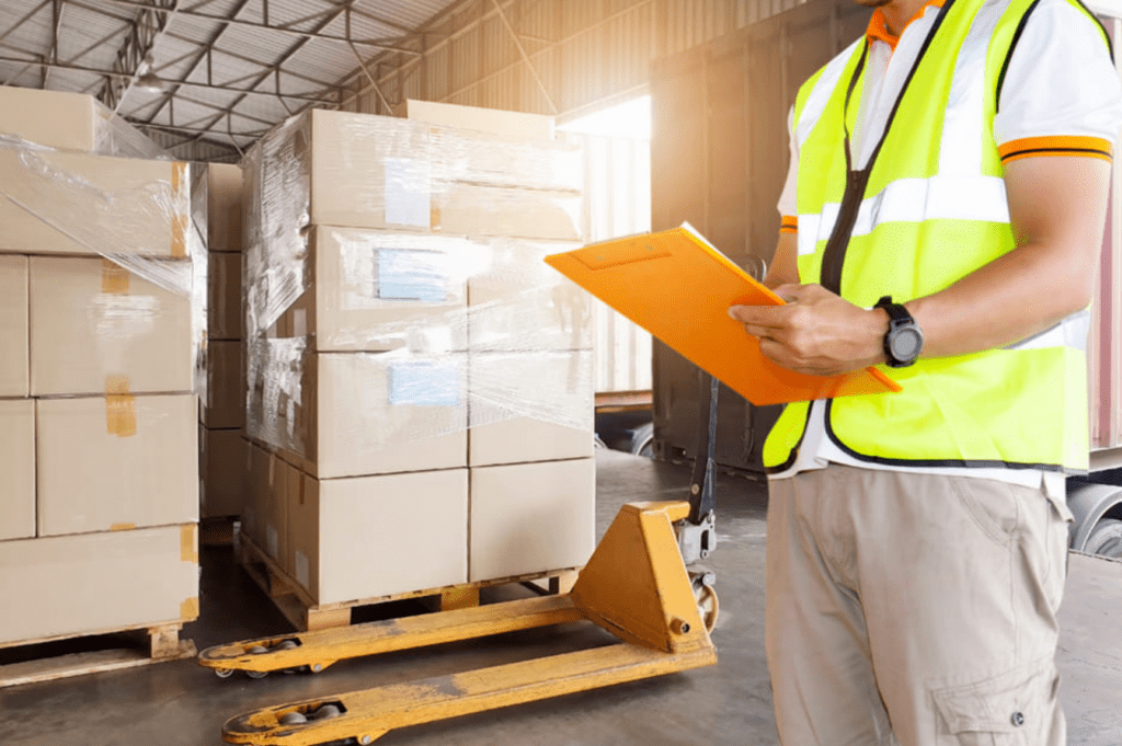 Miami cross-docking service worker checking freight during dock-to-dock transfer.
