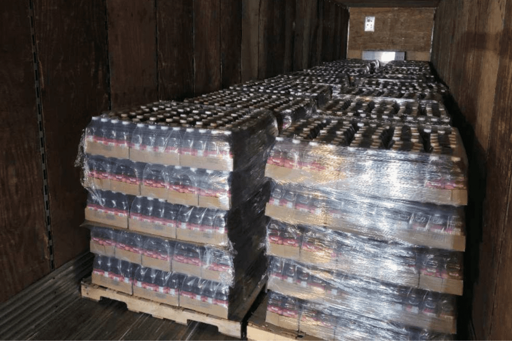 Re-stacked beverage pallets wrapped for stability and prepared for transport after pallet repair in Miami, Florida.