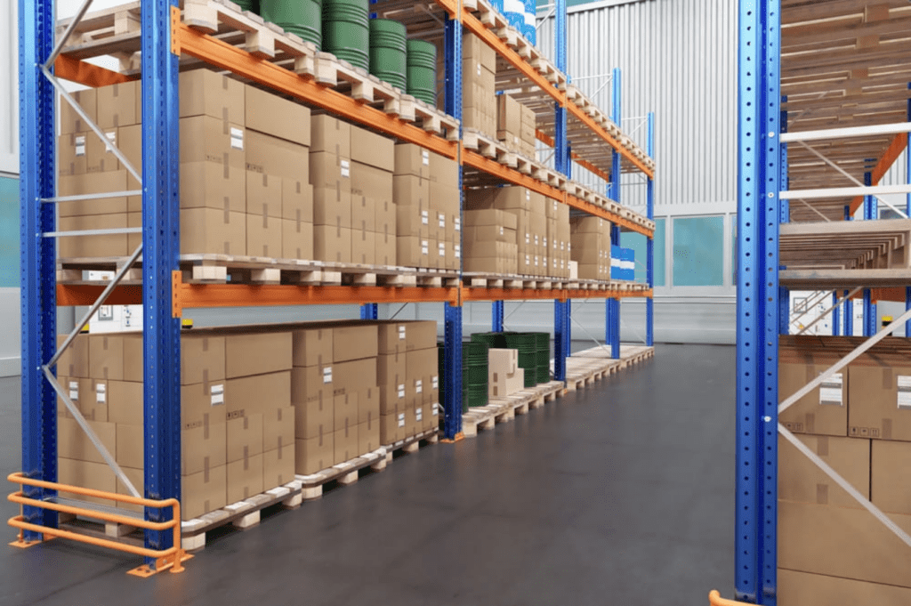 Industrial warehouse storage racks holding large hazmat drums and packaged goods at a Memphis storage facility.