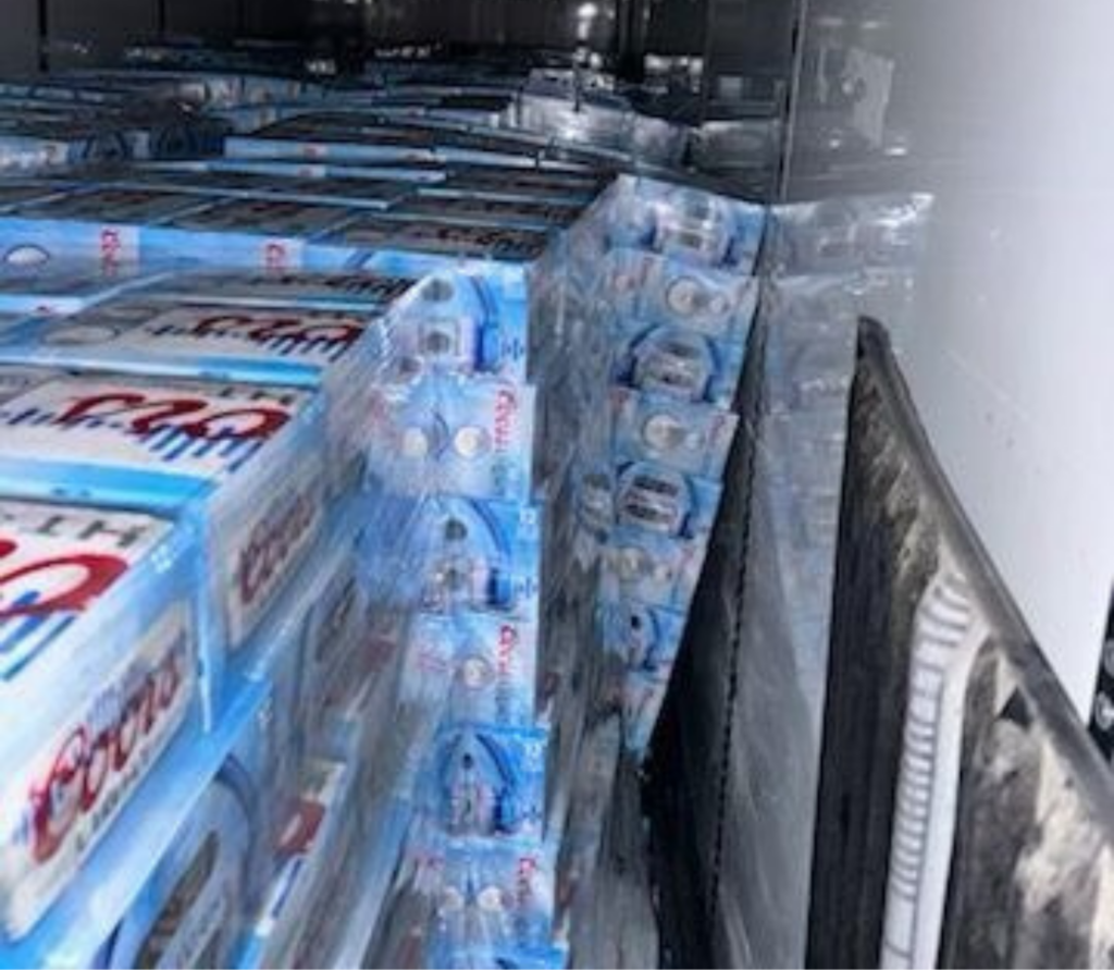 Forklift moving secured pallets during pallet rework operations close to major long beach freeways and port terminals.