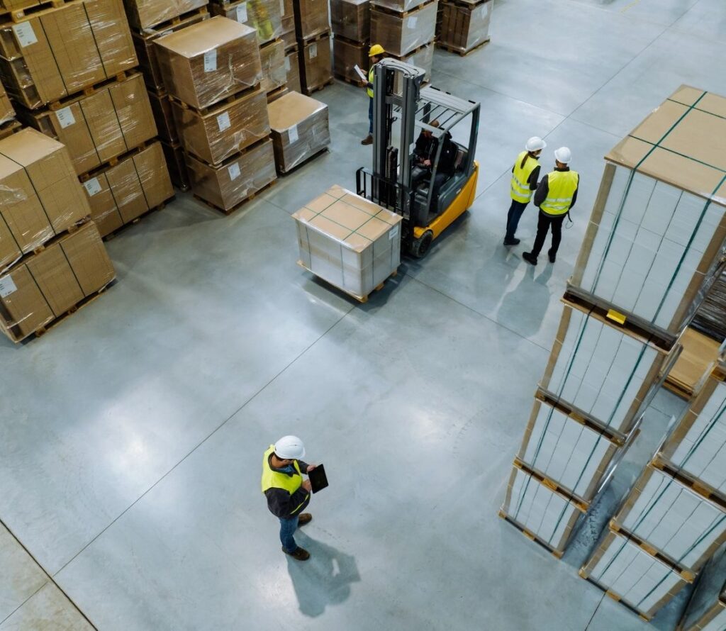 OLIMP's modern Milwaukee warehouse with tall pallet racks, workers scanning barcodes, and a forklift moving goods in a secure, well-organized facility.