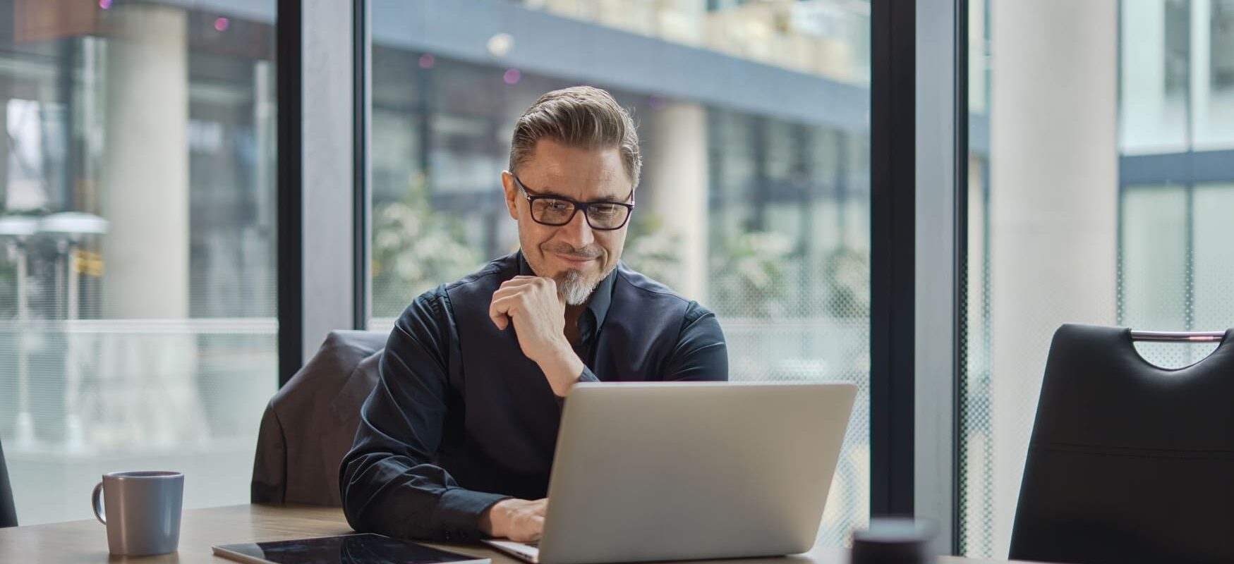 A logistics manager analyzing warehouse options on a laptop, comparing locations, pricing, and facility features to optimize supply chain operations.