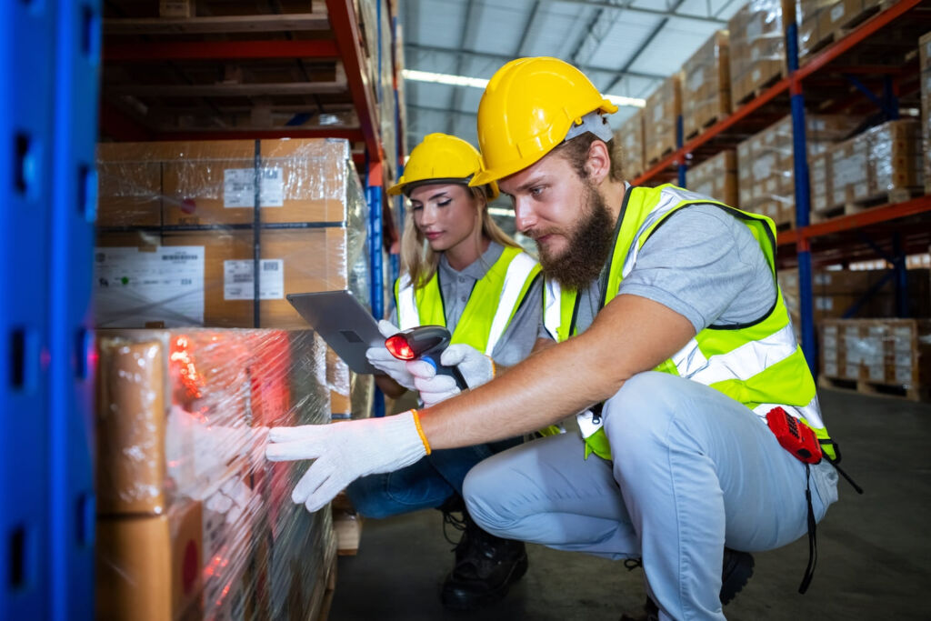 Warehouse employee verifying incoming inventory with a barcode scanner as part of receiving.