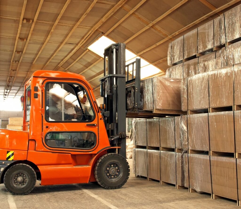 Forklift operator performing pallet rework and shrink-wrapping damaged pallets inside olimp warehouse in brattleboro
