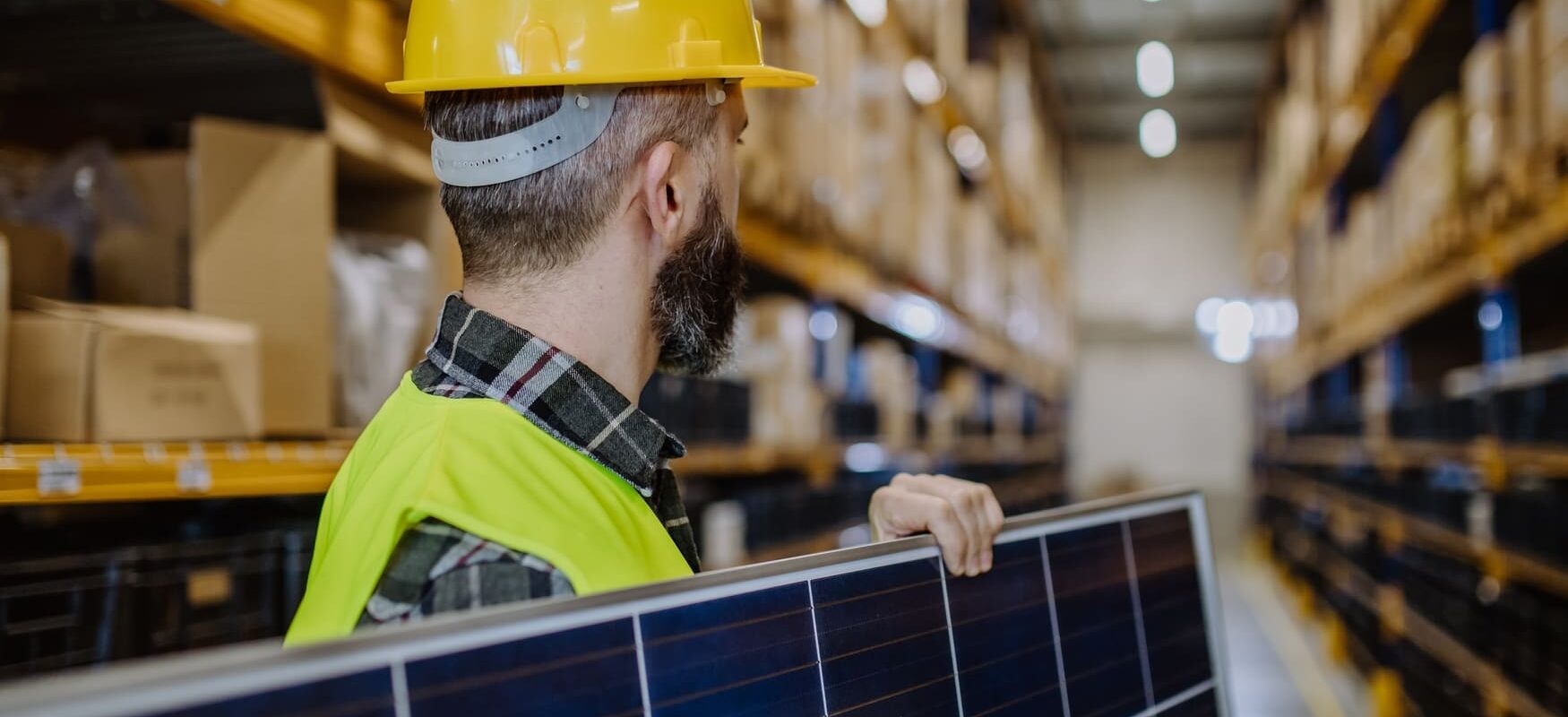 Warehouse workers carefully handling solar panels during the logistics process.