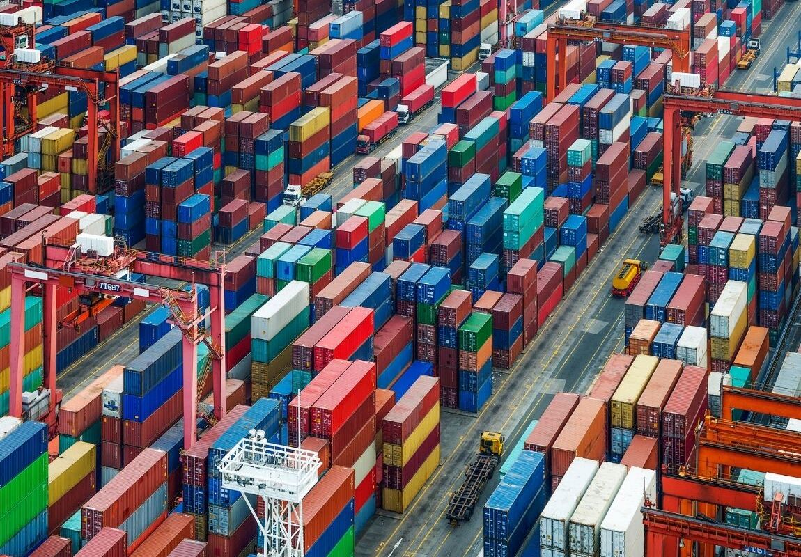 Shipping containers stacked at a busy U.S. port during peak import season, illustrating port congestion and global supply chain logistics.