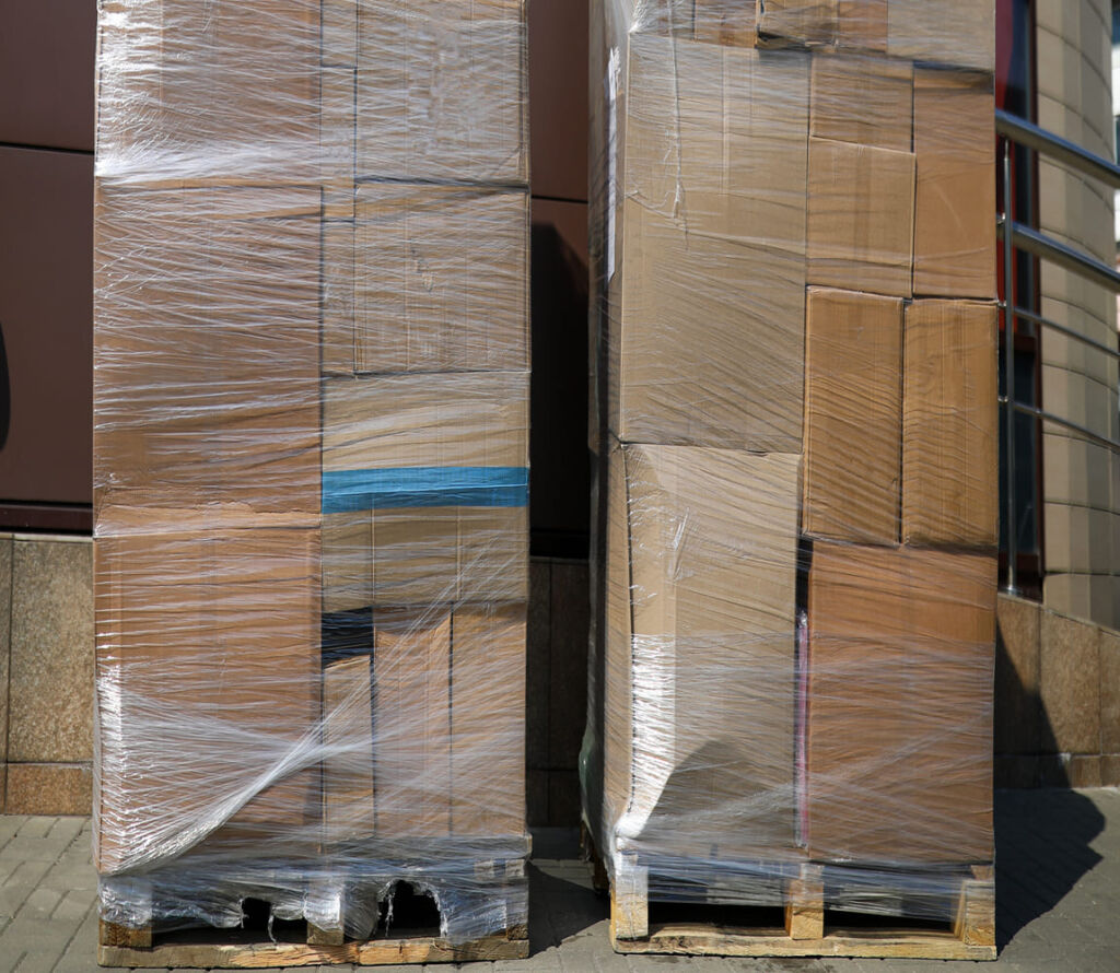 Warehouse workers reorganizing pallets for safe transport